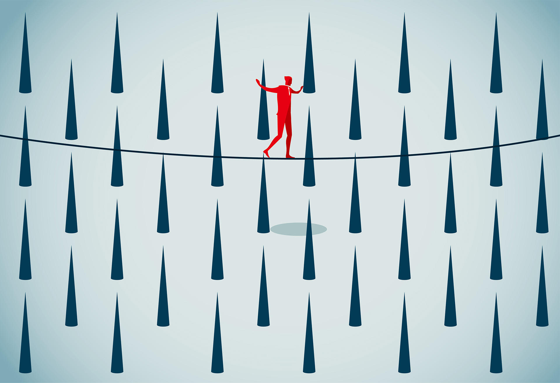 A man walking a tightrope over dangerous looking spikes